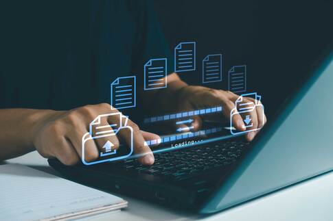 Person steuert Datenübertragung am Laptop